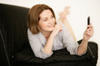 Frau mit Smartphone auf der Couch