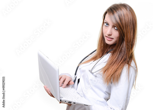 Photo: Female doctor making a notes using laptop Female doctor making a notes using laptop