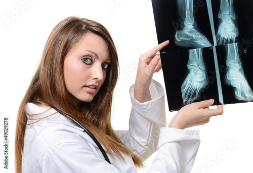 Photo: Attractive female doctor looking at X-ray image Attractive female doctor looking at X-ray image