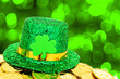 Photo: St Patricks Day hat and gold coins on green background St Patricks Day hat and gold coins on green background