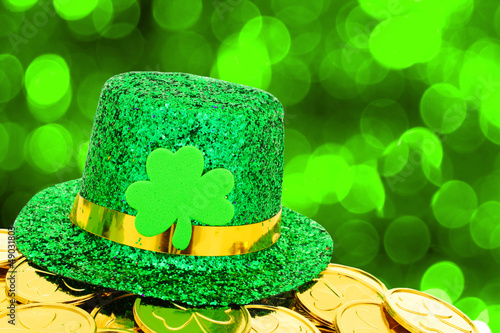 Photo: St Patricks Day hat and gold coins on green background St Patricks Day hat and gold coins on green background