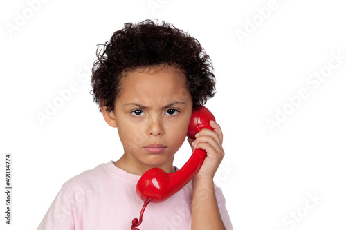 Photo: Angry latin child with red phone Angry latin child with red phone