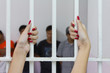 Woman fingers with red nails holding grip.