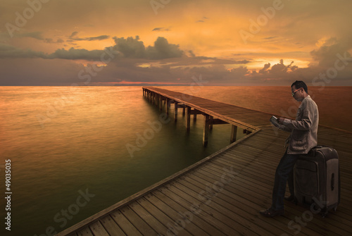 Photo: man reading a guide book on wood bridge man reading a guide book on wood bridge