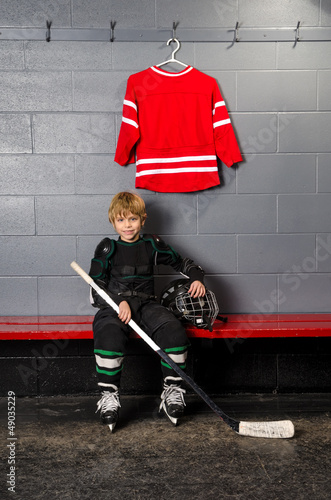 Photo: Young Boy in Hockey Dressing Room Young Boy in Hockey Dressing Room