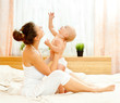 Mother and daughter play in the bedroom