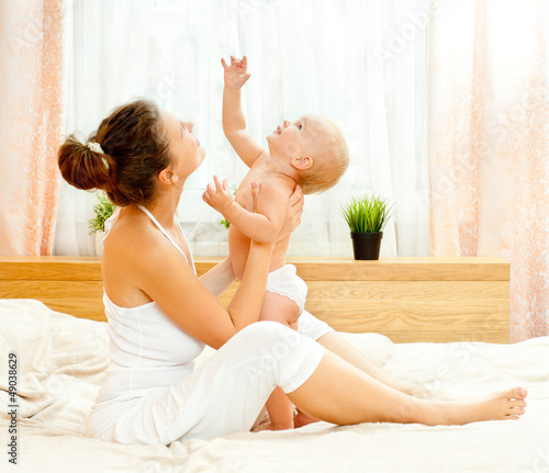 Photo: Mother and daughter play in the bedroom Mother and daughter play in the bedroom