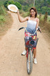 Girl with hat on a bicycle..