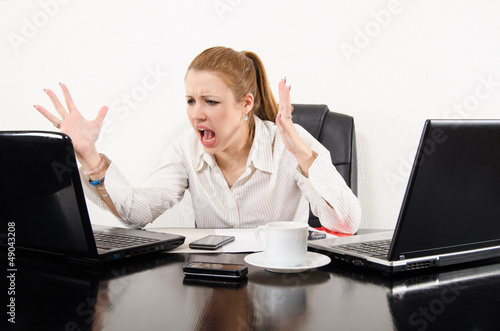 Photo: Business woman multitasking and frustrated by modern technology Business woman multitasking and frustrated by modern technology