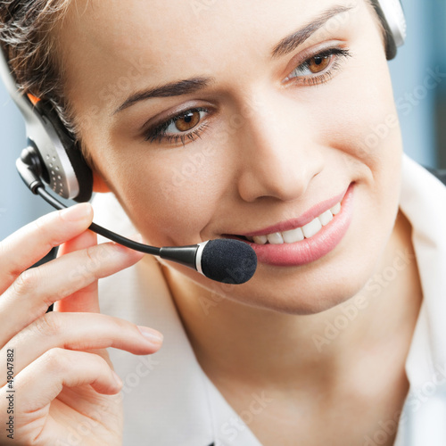 Photo: Happy smiling support phone operator at office Happy smiling support phone operator at office