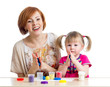 Foto: Happy child girl and mother sitting at table and playing with co Happy child girl and mother sitting at table and playing with co