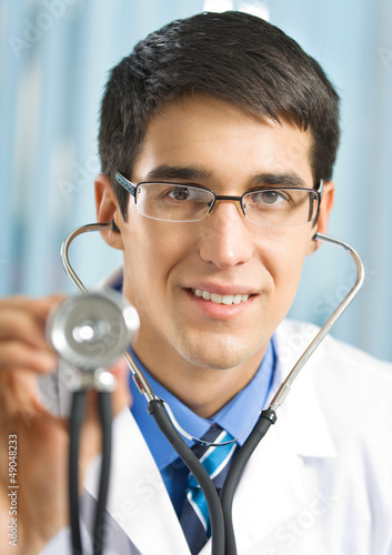 Photo: Happy doctor with stethoscope, at office Happy doctor with stethoscope, at office