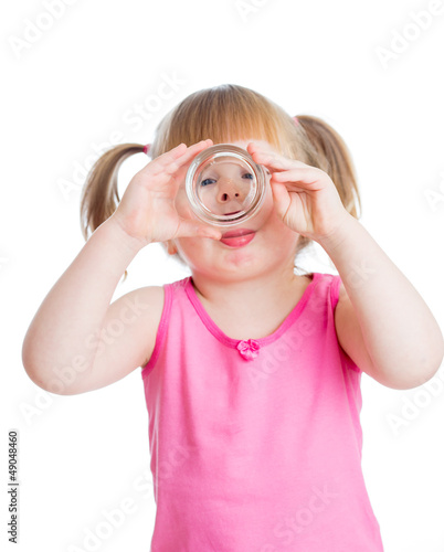 Photo: kid girl drinking water from glass over white background kid girl drinking water from glass over white background