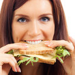 Cheerful woman eating sandwich with cheese