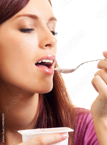 Photo: Cheerful woman eating yoghurt, over white Cheerful woman eating yoghurt, over white