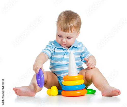 Photo: baby boy playing with colorful toy isolated on white baby boy playing with colorful toy isolated on white