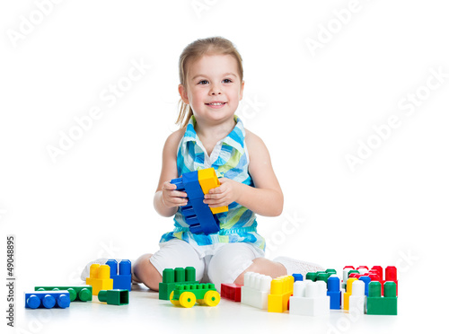 Photo: little cheerful child with construction set over white backgroun little cheerful child with construction set over white backgroun