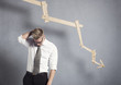 Photo: Disappointed businessman in front of graph pointing down. Disappointed businessman in front of graph pointing down.