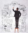 business man standing on a chair drawing