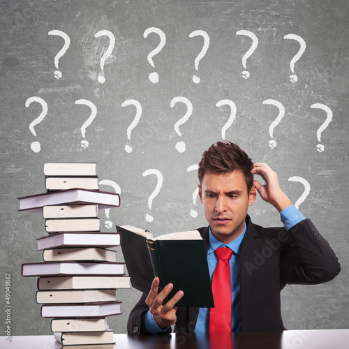 Photo: business man scratching his head while reading business man scratching his head while reading