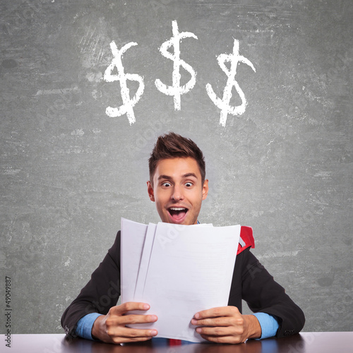 Photo: business man reading about how much he is earning business man reading about how much he is earning