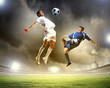 two football players striking the ball