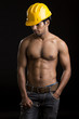 Foto: Healthy muscular young man with yellow helmet on black. Healthy muscular young man with yellow helmet on black.