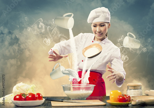 Photo: Asian female cooking with magic Asian female cooking with magic