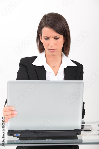 Photo: Brunette having technical issues with computer Brunette having technical issues with computer