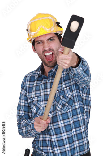 Photo: An angry construction worker with a sledgehammer. An angry construction worker with a sledgehammer.