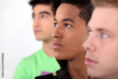 Photo: trio of male friends in profile looking in same direction trio of male friends in profile looking in same direction