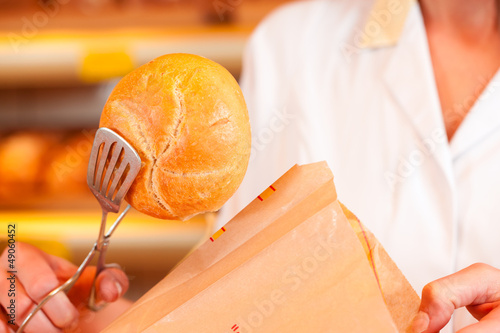 Photo: Salesperson is packing bread in bakery Salesperson is packing bread in bakery