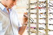 Photo: Young man at optician with glasses Young man at optician with glasses