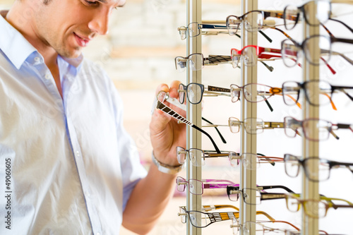 Photo: Young man at optician with glasses Young man at optician with glasses