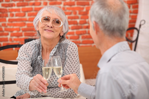 Photo: older couple toasting at restaurant older couple toasting at restaurant