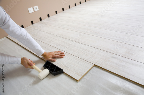Photo: Worker laying laminated Worker laying laminated