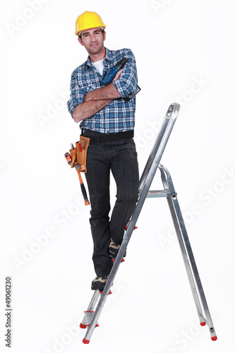 Photo: Tradesman standing on the steps of a stepladder Tradesman standing on the steps of a stepladder