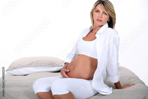 Photo: Pregnant blond woman sat in bed Pregnant blond woman sat in bed