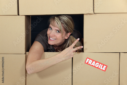 Photo: Woman in a wall of cardboard boxes Woman in a wall of cardboard boxes