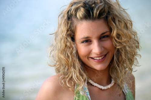 Photo: Cute curly-haired blond stood by the ocean Cute curly-haired blond stood by the ocean