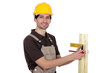 portrait of young carpenter taking measurements