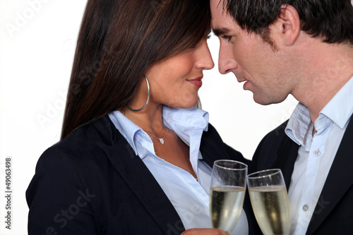 Photo: Flirtatious business couple drinking champagne Flirtatious business couple drinking champagne