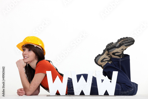Photo: Female builder laying by large WWW letters Female builder laying by large WWW letters