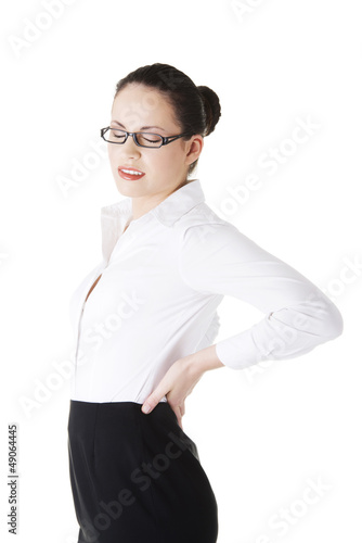 Photo: Businesswoman with back ache after long work. Businesswoman with back ache after long work.