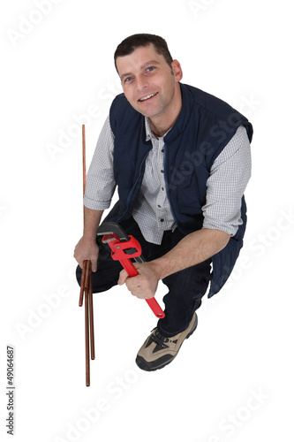 Photo: Plumber with a wrench and copper pipe Plumber with a wrench and copper pipe
