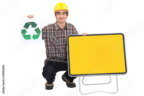 Photo: Young manual worker with recycle logo and blank road sign Young manual worker with recycle logo and blank road sign