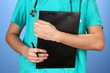 Hand of doctor with prescription blank, on blue background
