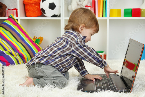 Photo: cute little boy and notebook in room cute little boy and notebook in room