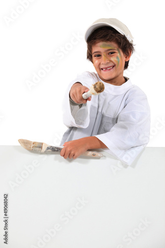 Photo: schoolboy wearing overalls enjoying painting schoolboy wearing overalls enjoying painting