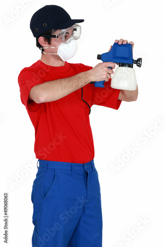 Photo: Man holding a paint sprayer Man holding a paint sprayer